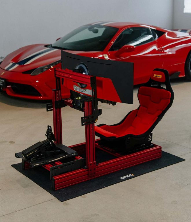 SPEC 282 sim rig, red frame, parked beside a car in a showroom