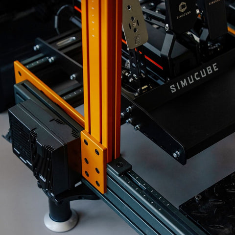 Close-up of a SIMUCUBE 3D printer with orange and black components.