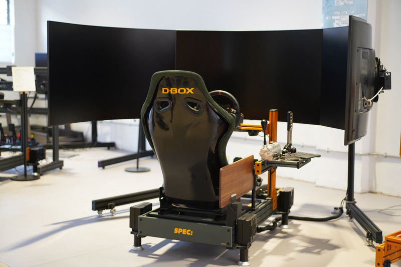 A D-BOX motion seat on a SPEC base in front of three curved screens