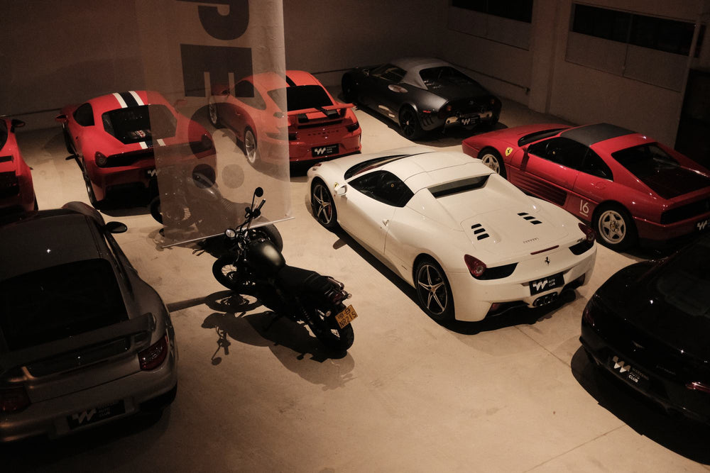 Sports cars and a motorcycle parked on the studio floor, seen from above